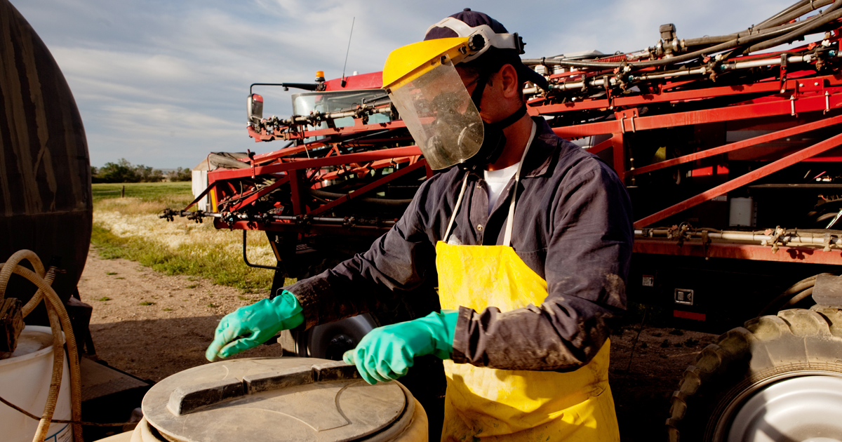 using proper safety equipment to fill sprayer with chemical and water