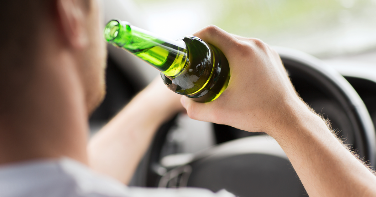 man drinking alcohol while driving