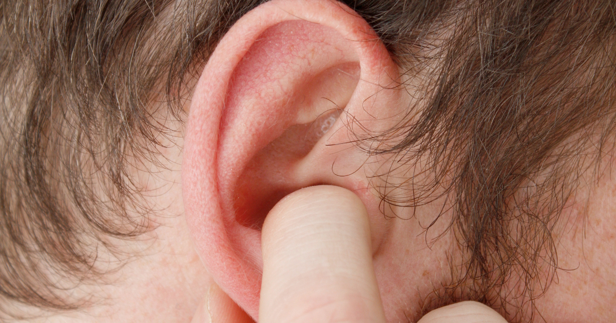 close up of man holding finger in ear