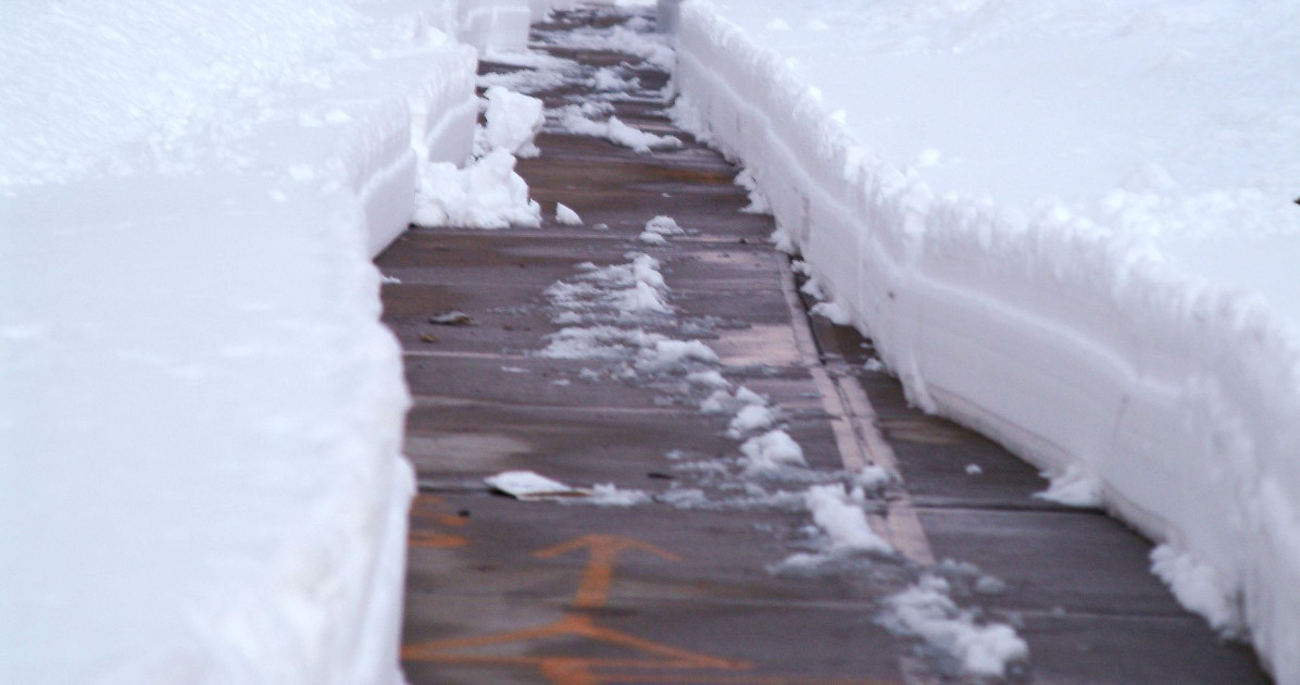 Icey sidewalk with snow drifts on each side