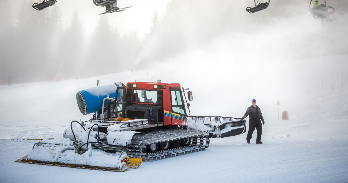 Snow cleaning machine working on ski slope 