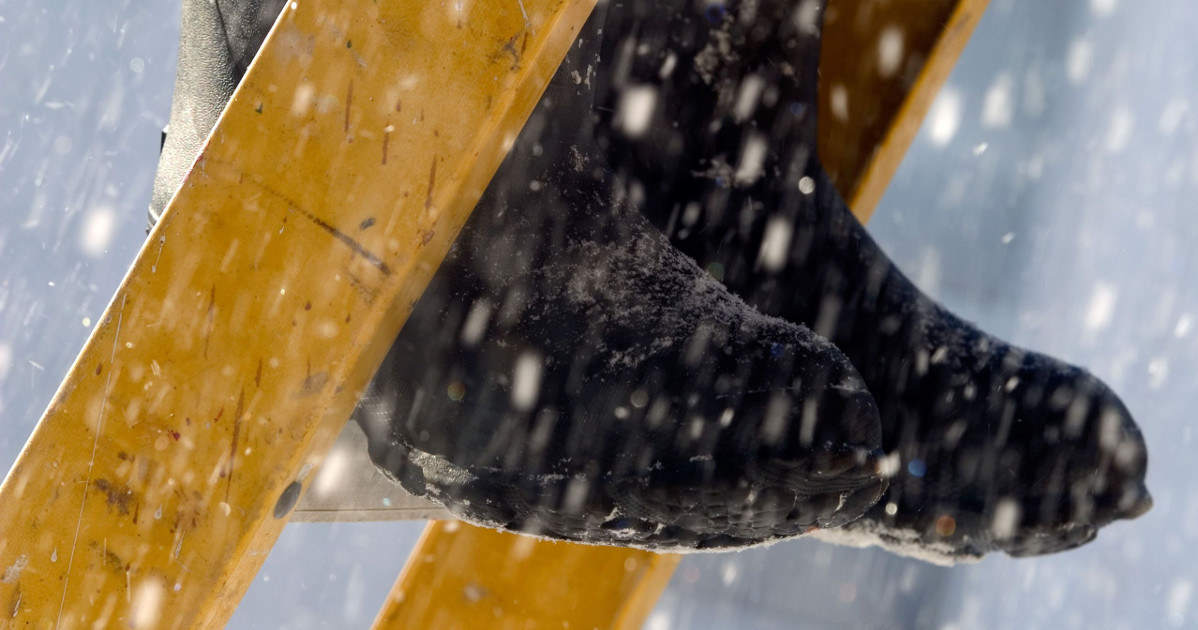 rubber boots on yellow ladder in snow