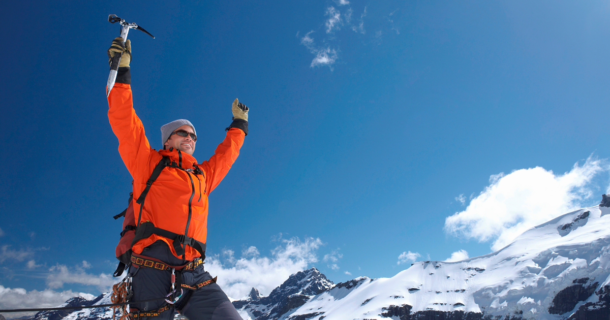 mountain climber at top of peak